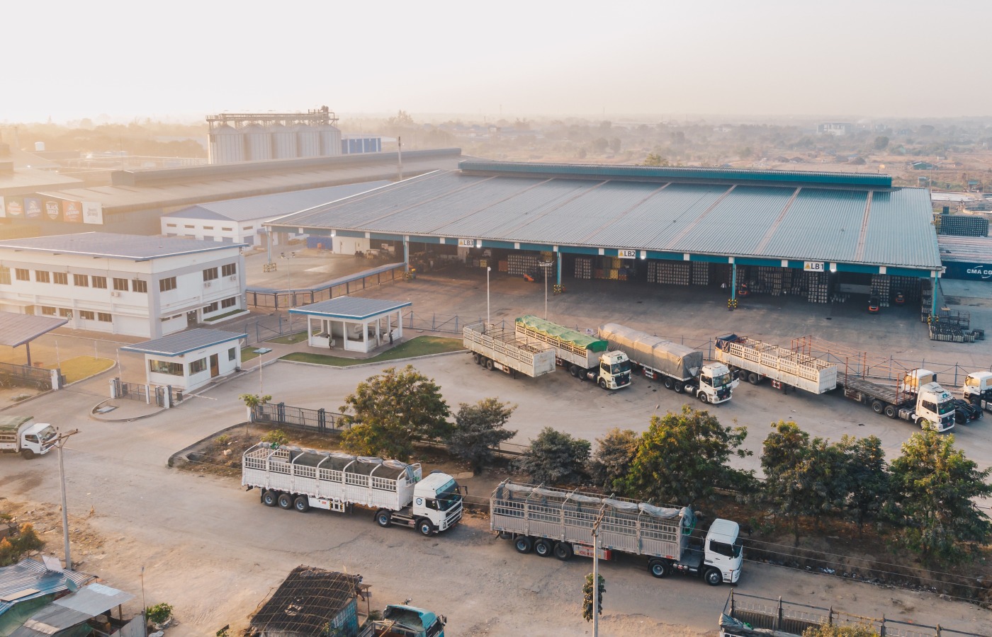 Aerial view of an industrial warehouse with loading docks and freight trucks